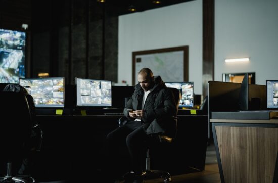 Operator przy ścianie monitorów w centrum monitoringu